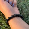 black obsidian 10mm natural gemstone bracelet in left hand