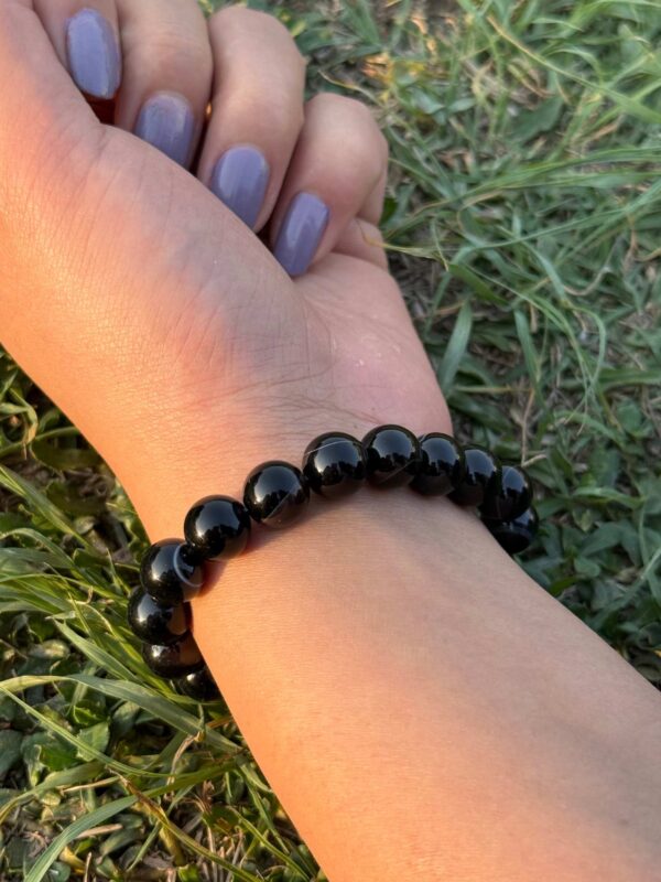 black obsidian 10mm natural gemstone bracelet in left hand