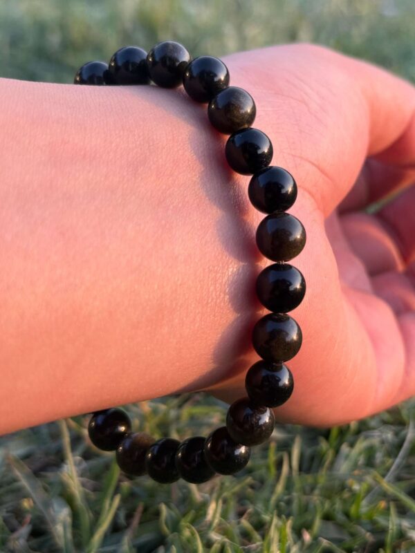 black obsidian natural gemstone bracelet in left hand