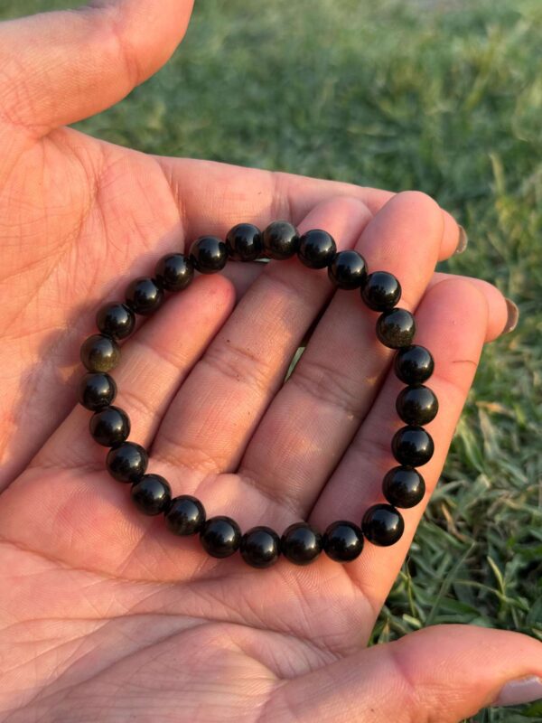 black obsidian natural gemstone bracelet in palm