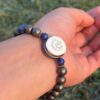 gold obsidian natural gem stone bracelet with guru bead in left hand