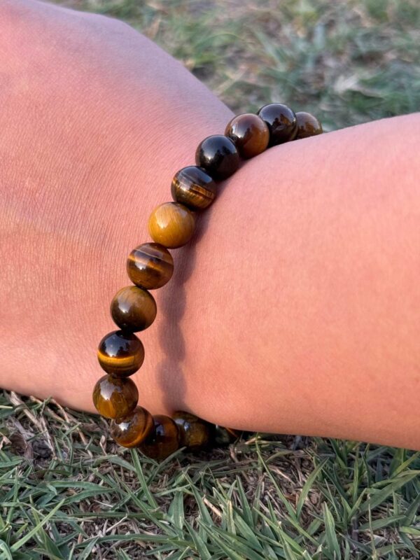 tiger eye natural gemstone bracelet in left hand